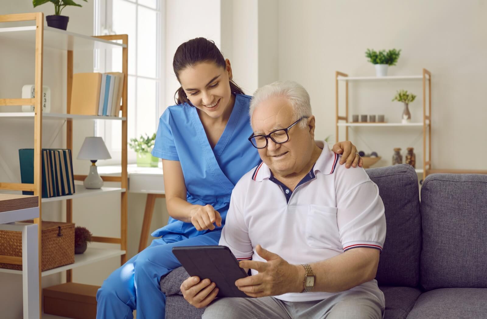 Memory care resident receiving assistance with using technology.
