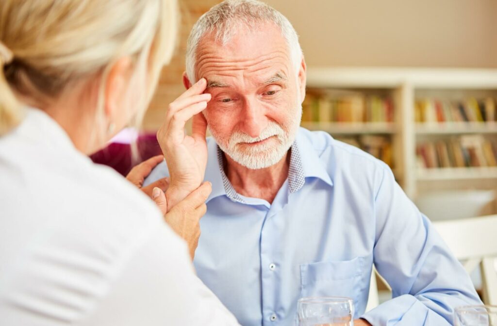 a senior showing early signs of alzheimers getting help from a caregiver