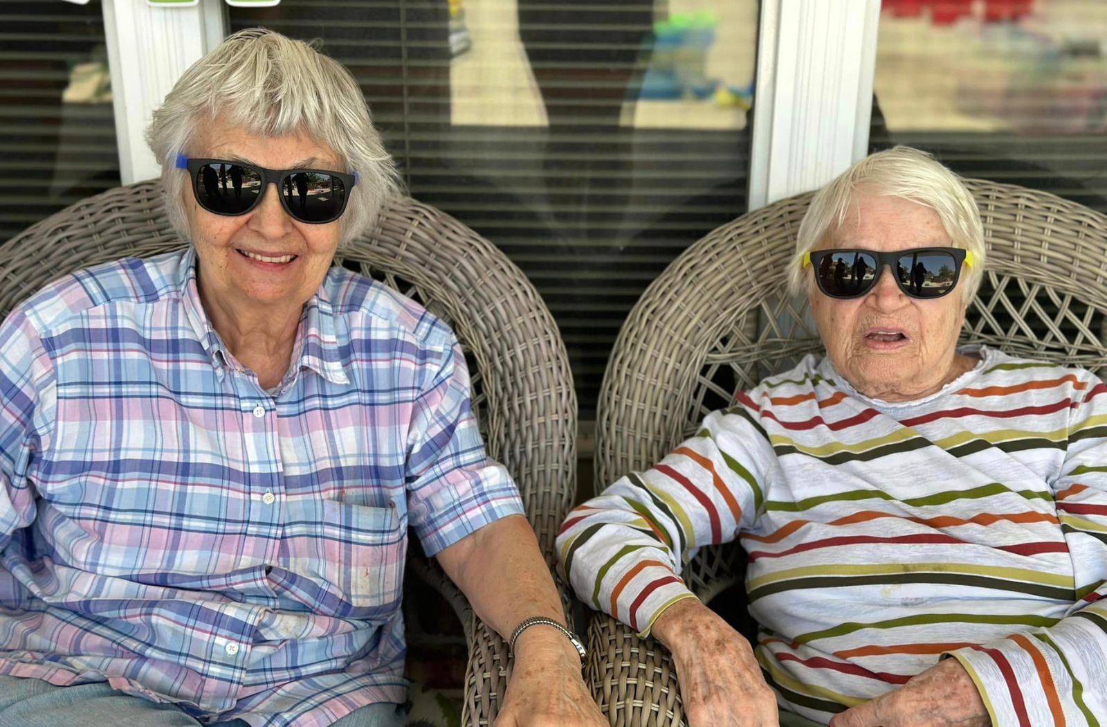 two senior roommates sitting next to each other with sunglasses