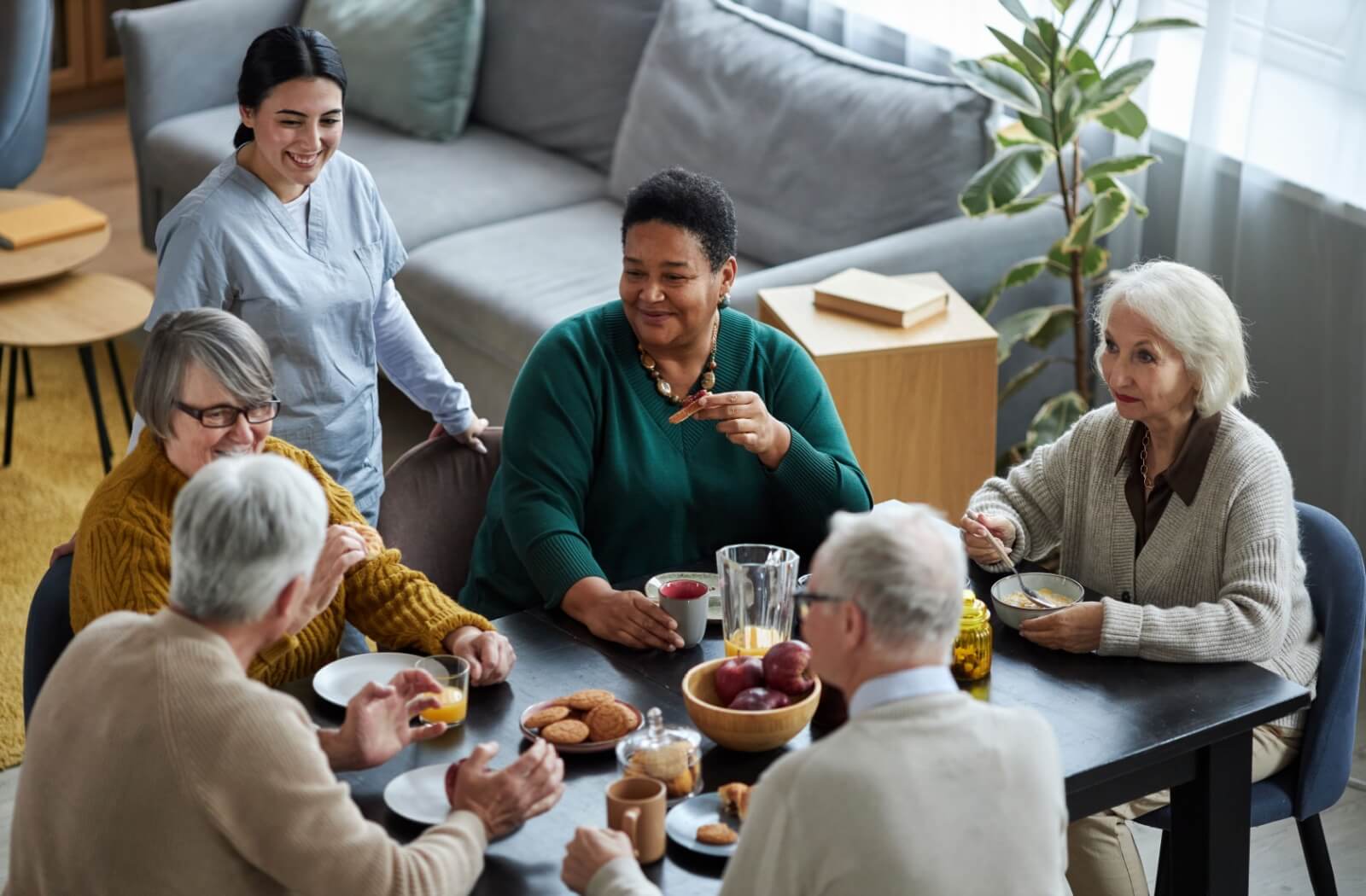 a group of seniors having a meal together in assisted living