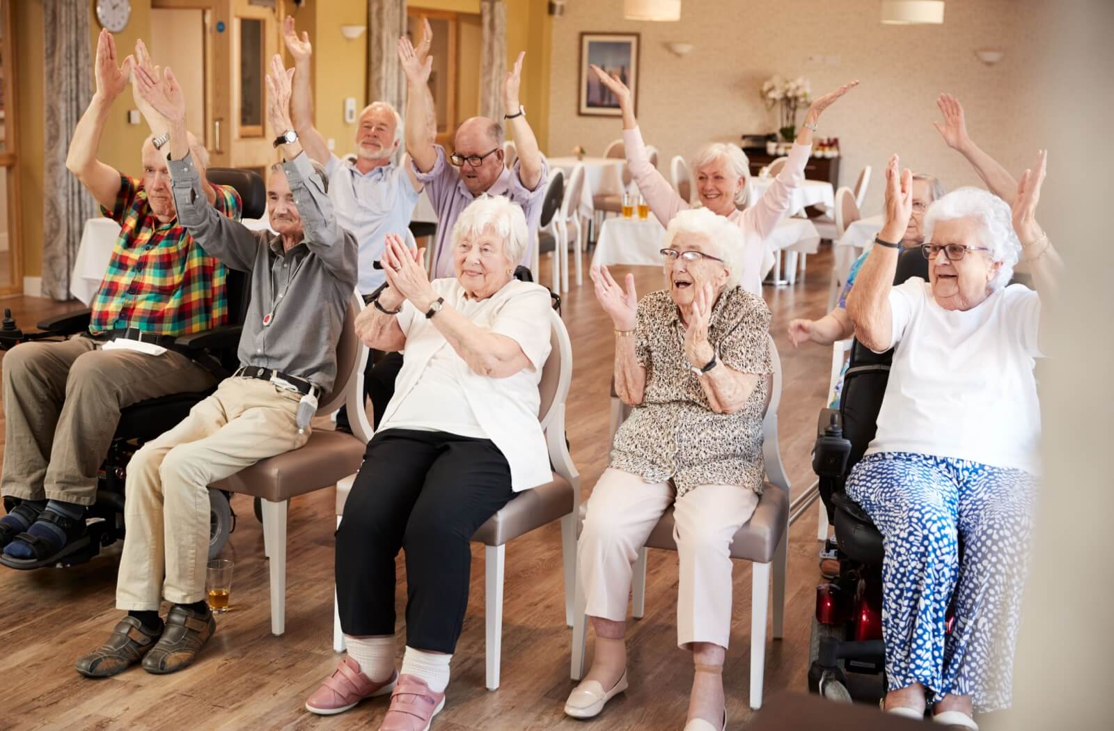a group of seniors clapping together in a behavioral assisted living community